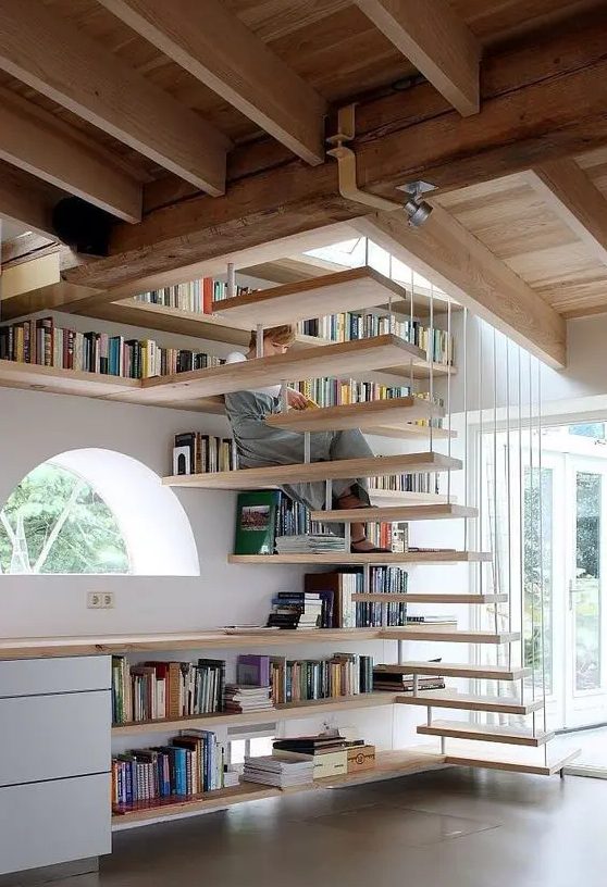 bookshelves covering the whole wall and under the space under the stairs are an effective solution