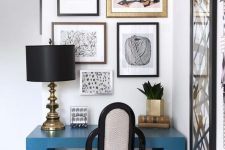 41 a small space with a beautiful gallery wall. a bold blue desk, an elegant art deco chair and a chic black and gold lamp