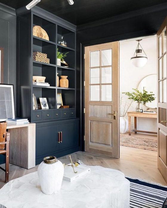 a black space with a blonde wood floor, doors and a desk looks more lightweight and more contrasting at the same time
