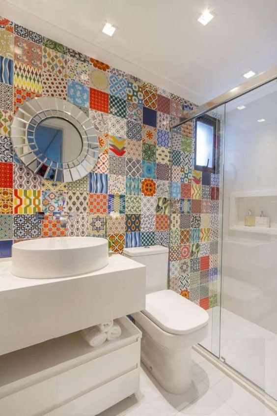 a bold bathroom with a multi color and print tile wall for a statement and all wihte everything around is a vibrant and fresh solution
