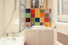 a bright bathroom with a red square tile floor and a bold multi color tile backsplash in the sink zone is a very fresh and bold idea