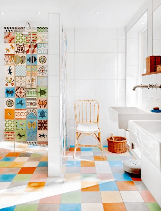 a bright multi color tiled bathroom with just colorful and printed tiles in the shower, with white appliances to create a balance