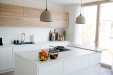 a chic minimalist kitchen with light-stained and white cabinets, a sleek white kitchen island with storage compartments and a countertop for eating
