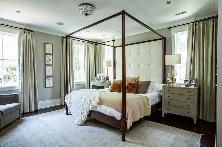a chic modern bedroom done in neutrals, with a dark stained framed bed, mismatching dressers as nightstands, a chic chair and neutral textiles