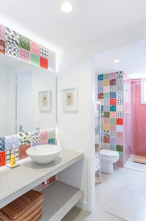 a contemporary bathroom accented with red tiles in the shower space and with super bold printed tiles in the sink and toilet space