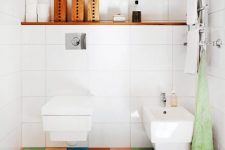 a contemporary bathroom done in white, with a super colorful tile floor that adds a cheerful feel to the space and makes it fun