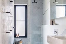 a contemporary bathroom with large scale tiles, neutral appliances and a cool walk-in shower with a window and a glass door
