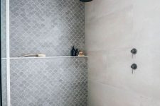 a contemporary bathroom with neutral large scale and grey fishscale tiles with no doors at all