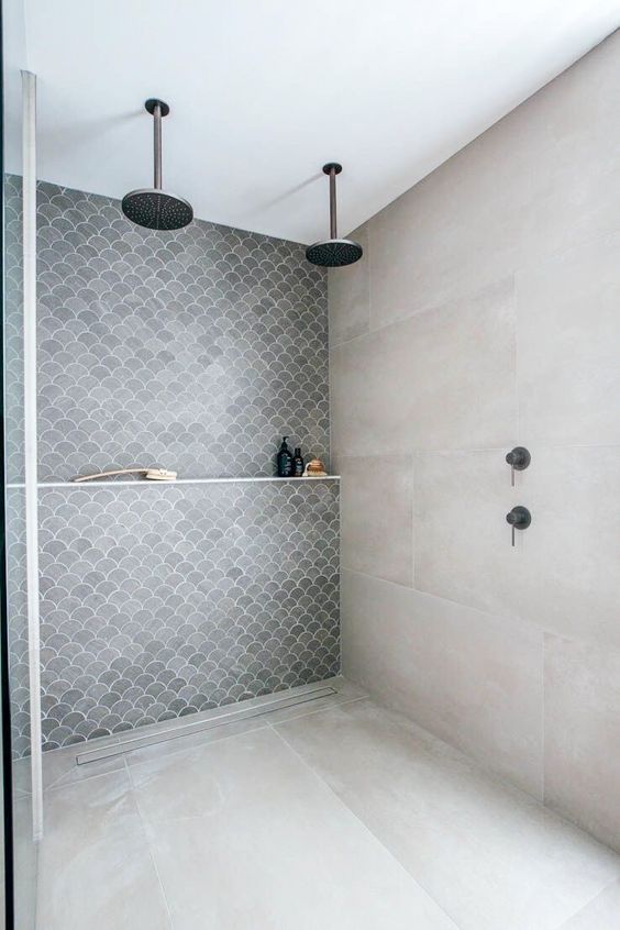 a contemporary bathroom with neutral large scale and grey fishscale tiles with no doors at all