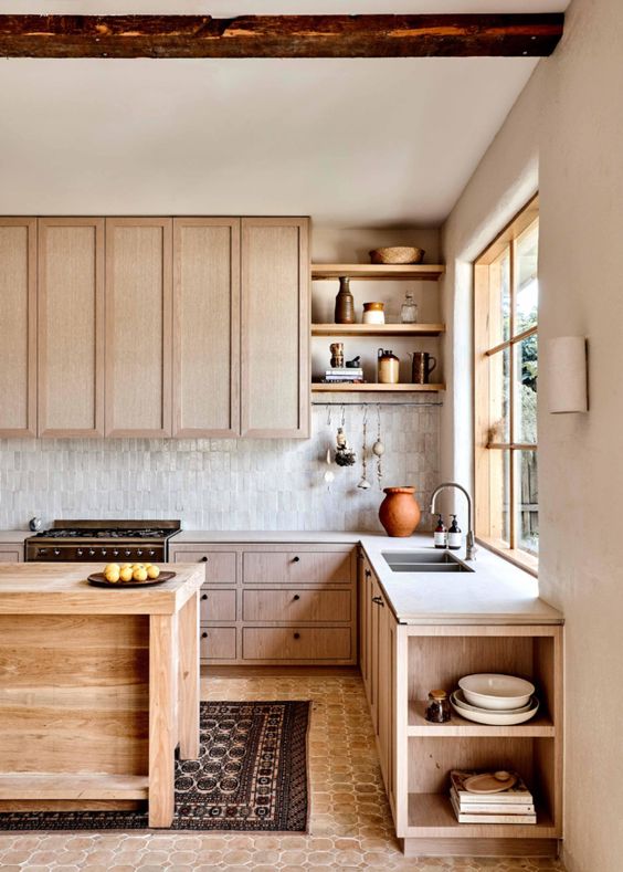 a contemporary blonde wood kitchen with skinny marble tiles on the backsplash and white countertops, open shelves and rough wooden beams