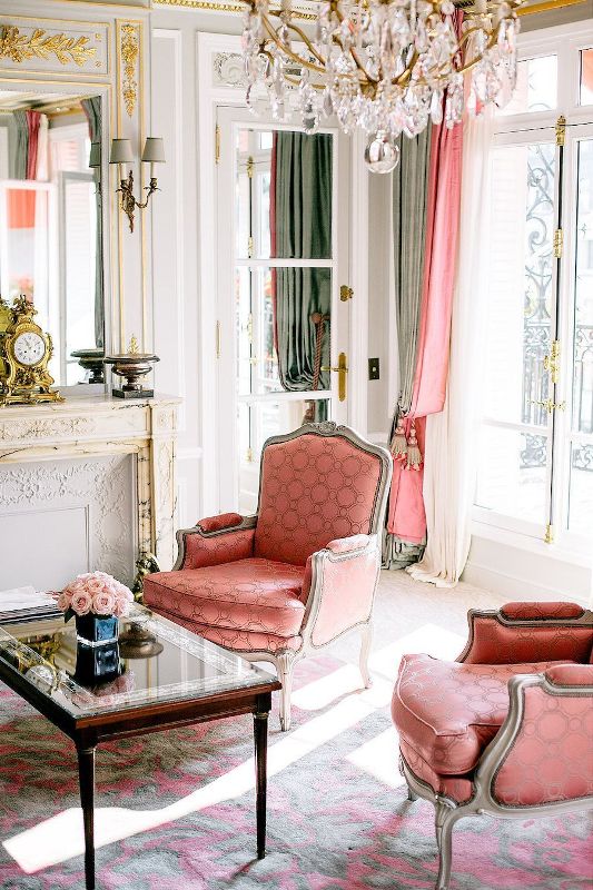 a gorgeous Parisian chic living room done in pastel green and coral is amazing with its marble fireplace and vintage furniture