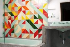 a modern bathroom with concrete and super bright geometric tiles accenting the green bathroom is amazing