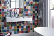 a modern white bathroom with an accent wall clad with super bright and bold tiles and with all white everything looks cool and cheerful