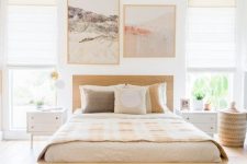 a neutral bedroom with a blonde wood bed, white nightstands, printed textiles and lovely artworks is pure chic
