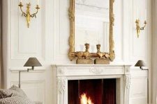 a neutral living room with a chic working fireplace that is accented with a vintage frame mirror that adds style