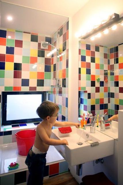 a pretty and bright bathroom with a multi color tile shower space is a great idea for a kid's bathroom