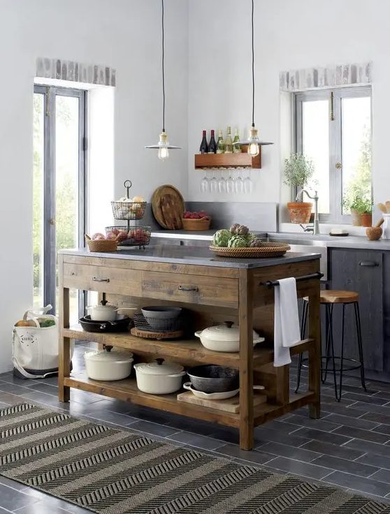 a small Scandi kitchen with black cabinets, white countertops, pendant lamps, vintage fixtures, a stained wood kitchen island with drawers and open shelves