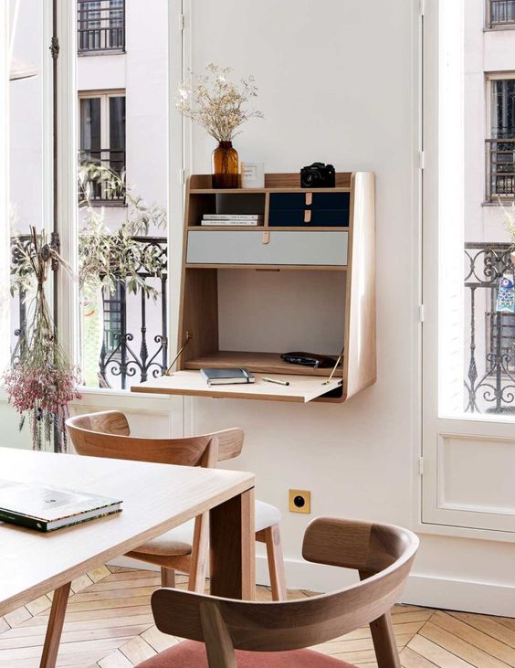 a small and elegant Murphy desk of light-stained wood, with built-in mini drawers for storage