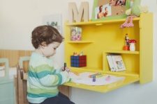 a sunny yellow Murphy desk with toys, photos and monograms is a great solution for a kid’s room