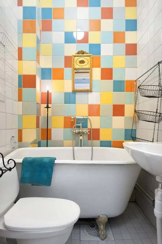 a tiny and colorful bathroom with a multi-color tile accent wall, white appliances and a turquoise towel is amazing