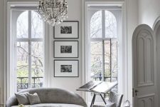 a white French chic living room with a chic and sophisticated crystal chandelier that adds to the style