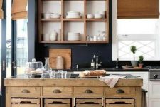 a white and stained farmhouse kitchen with navy walls, shades, a stained wood kitchen island with casters, with drawers, crates and baskets is cool