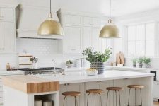 a white farmhouse kitchen with shaker style cabinets, white stone countertops, a white subway tile backsplash and a storage kitchen island with open storage niches