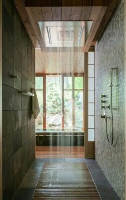 an East inspired walk in shower with a wooden floor, stone like tiles and a rain shower for a real spa like feel