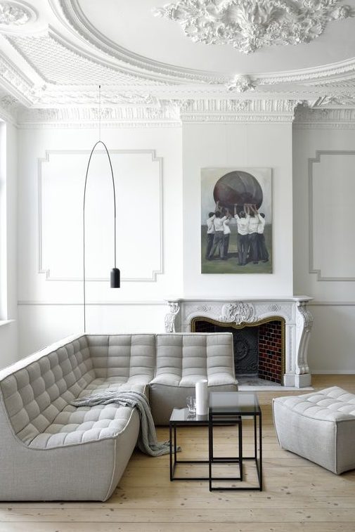 an all-white French style living room done right with a light grey sofa and some touches of black for a bit of drama