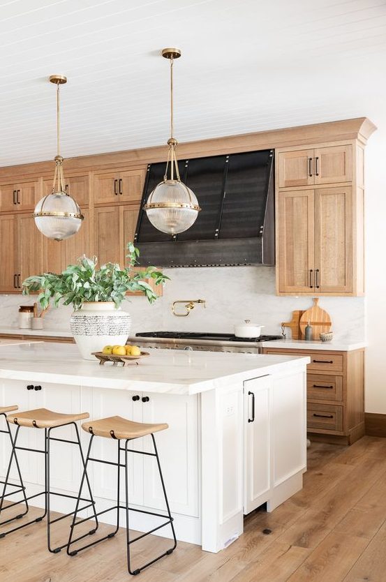 an amazing modern farmhouse kitchen with blonde wood cabinets a white kitchen island pendant lamps and blonde wood stools