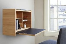 an elegant minimalist Murphy desk done in light colored plywood and navy, with stylish and neat storage compartments inside