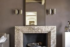 an exquisite taupe living room with a non-working fireplace, a refined mirror, metallic sconces, white ottomans and poufs and taupe furniture