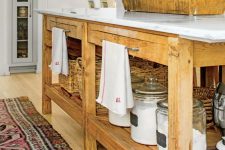 an oversized stained kitchen island with open shelves for storage and holders for towels is a very functional and cool solution