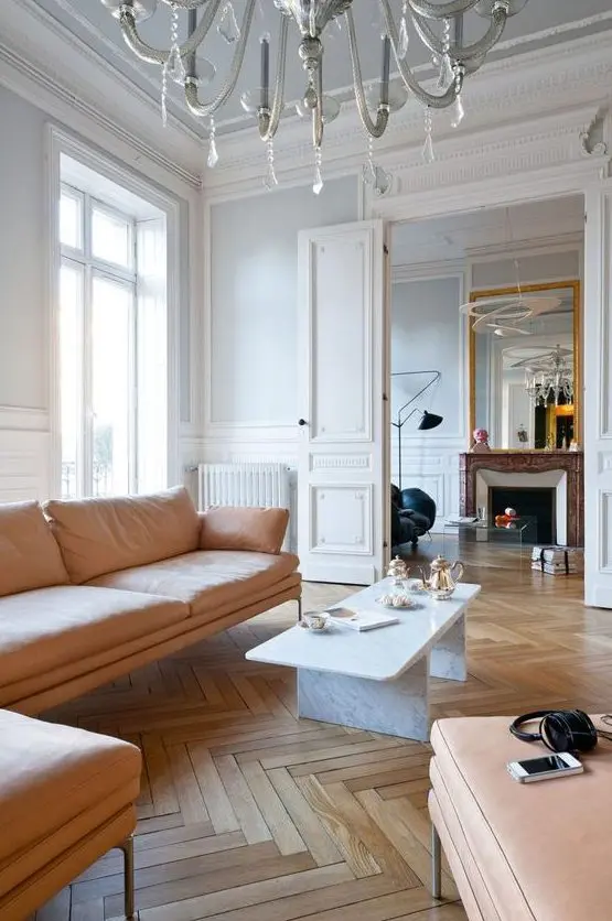 pair white walls and hardwood parquet floors adding soft peachy furniture to soothe the space