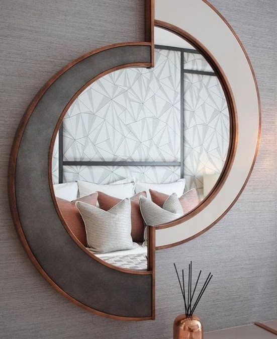 a chic sculptural mirror in white and grey, with copper framing is a beautiful decoration that will add light