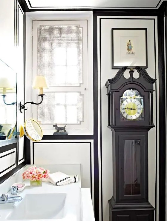 a black grandfather's clock incorporated into a chic art deco bathroom looks absolutely organic here and adds to the style of the space