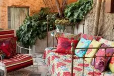 03 a shabby chic metal daybed with colorful blankets and pillows for a gypsy boho outdoor space
