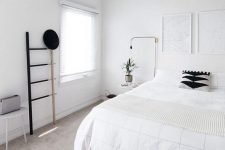 05 a clean Nordic bedroom with a white bed, artworks, a ladder, lamps and a stool – blakc for drama