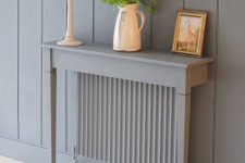 05 a grey radiator with a matching grey half console table with blooms, art and a white lamp is a lovely idea for a modern space