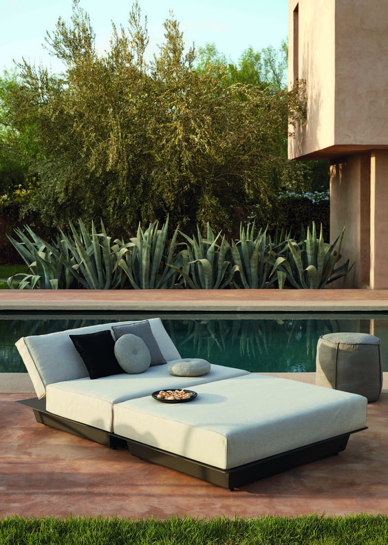 a modern oudoor daybed with an arrangement of pillows, a pouf is a great idea for a pool zone or just to relax somewhere outdoors