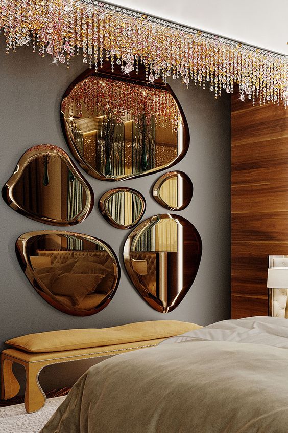 an arrangement of beautiful cognac-colored mirrors of unusual shapes, with crystals over the bench for glam bedroom styling