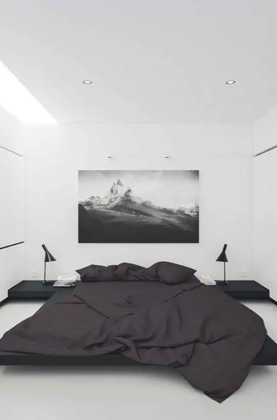a minimalist bedroom in black and white with lots of negative space thanks to the high ceiling for a relaxed feeling