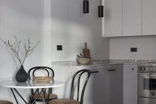 13 a minimalist grey Nordic kitchen with black pendant lamps, a grey stone countertop and a table with hairpin legs