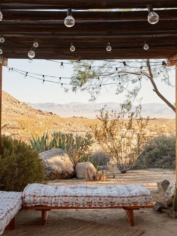 a cabana with lights and a a couple of simple wooden daybeds with printed mattresses is a lovely idea for outdoors, it's super cool