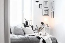 14 a monochromatic Scandi bedroom with a bed with grey and white bedding, some lamps, lights and a gallery wall