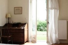 15 a vintage-inspired bedroom with much negative space for a relaxed feeling and doors to the garden