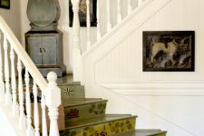 17 a quirky vintage space in neutrals, with a green staircase with painted steps, a grey grandfather clock and a bold gallery wall over the stairs