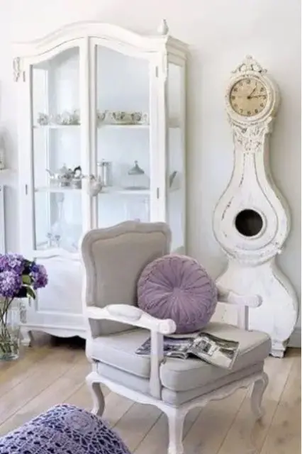 a refined chair, an antique glass armoire and a shabby chic grandfather's clock compose a lovely combo for a neutral shabby chic living room