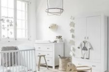 20 a pure white Scandinavian nursery with a dresser, a wardrobe, a crib, some stools and a pendant lamp plus pretty and cute decor