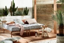 23 a simple and welcoming wooden daybed with a comfy mattress and pillow placed in a cabana to avoid sunlight